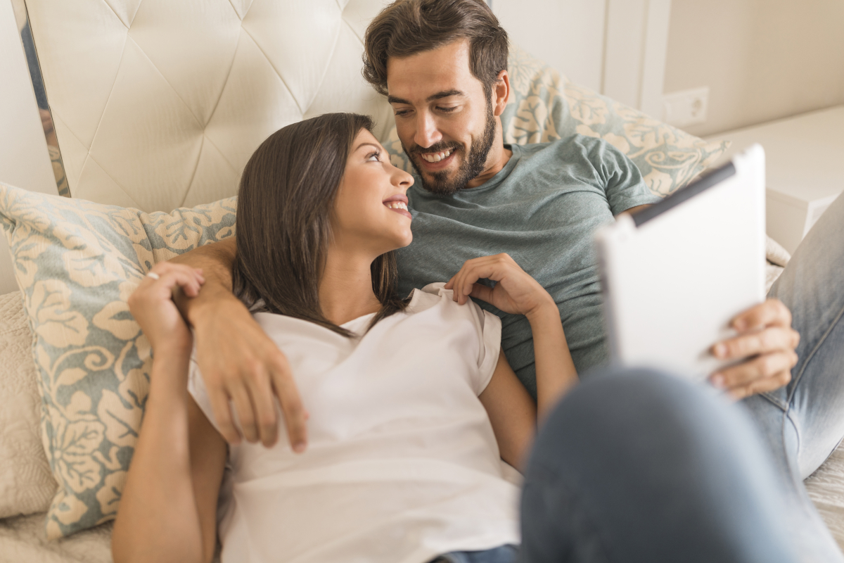 couple-with-tablet-lying-bed